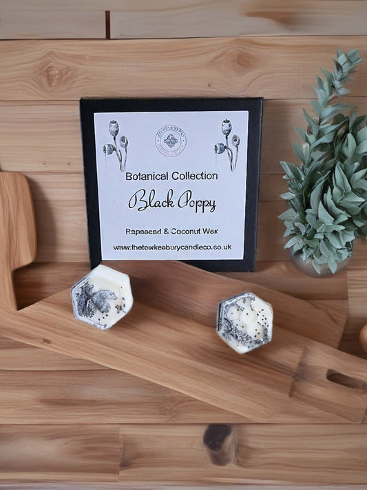 Black Poppy Botanical Wax Melts on a wooden surface.