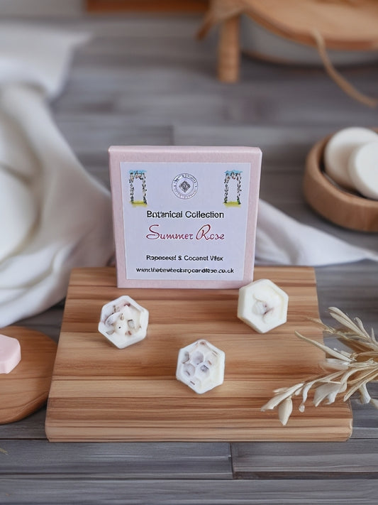 Summer Rose Botanical wax melts on a wooden stand with a blurred background