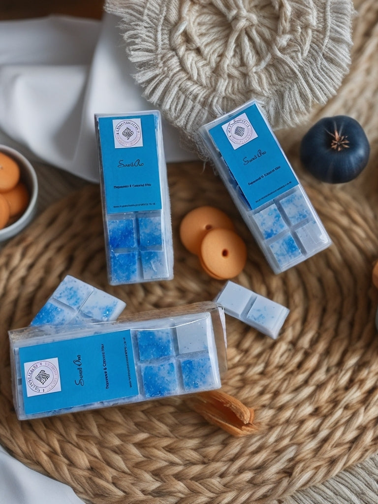 Blue wax melts in clear containers on a woven surface with decorative items.